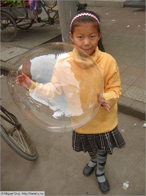 China: Sichuan Province: Showing off her big bubble